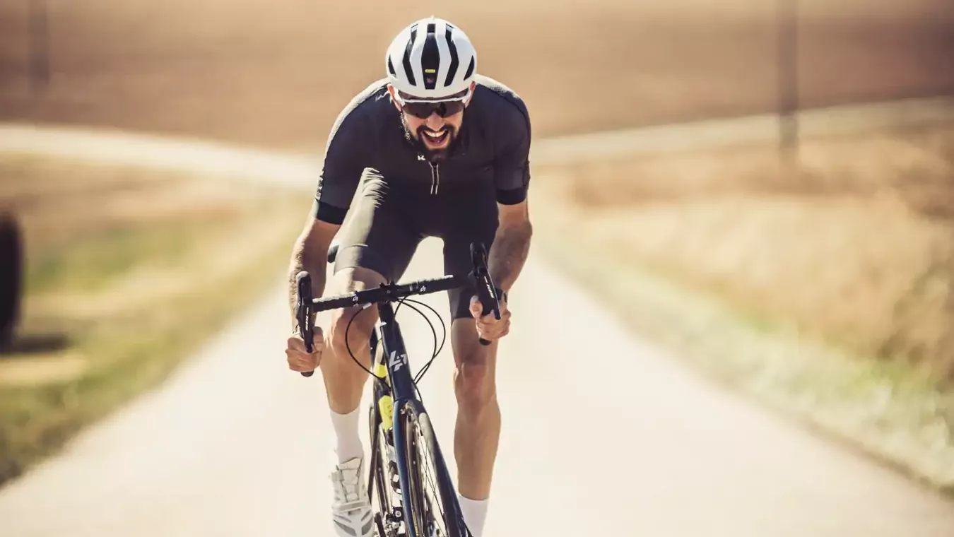 A man riding a Lapierre road bike up a hill